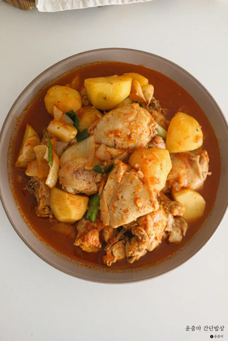 손질 전 닭과 감자, 양파가 놓인 재료 사진